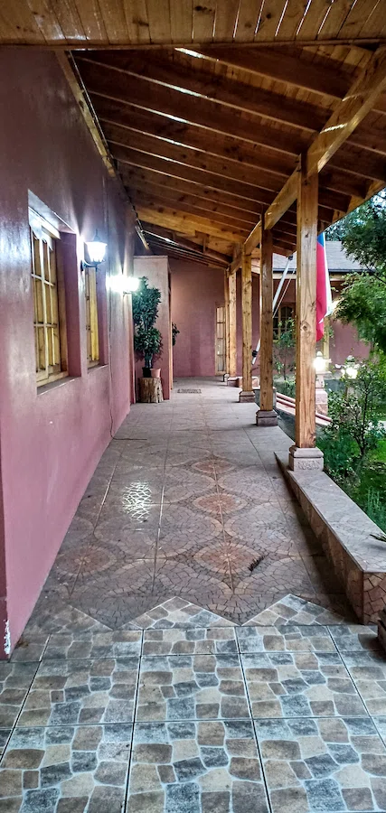 Corredor exterior techado con pilares de madera y piso cerámico en casa sólida sector Roma, San Fernando.